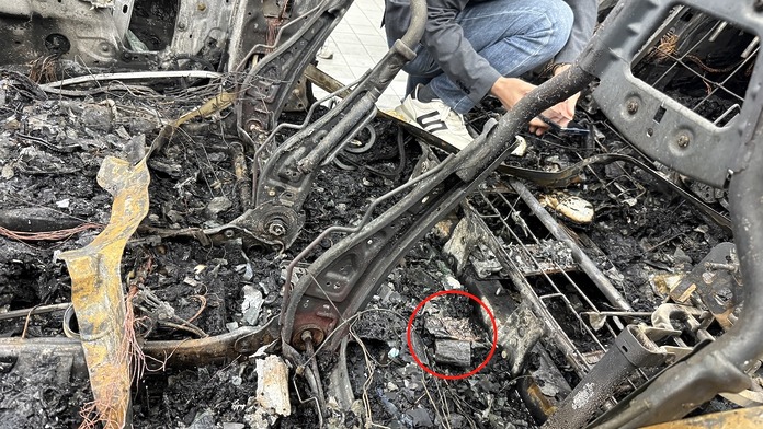 比亞迪提供焚毀車輛殘骸照片顯示起火源頭位於後排座椅中間位置，判定為車主放置於車廂內的一枚行動電源引致。