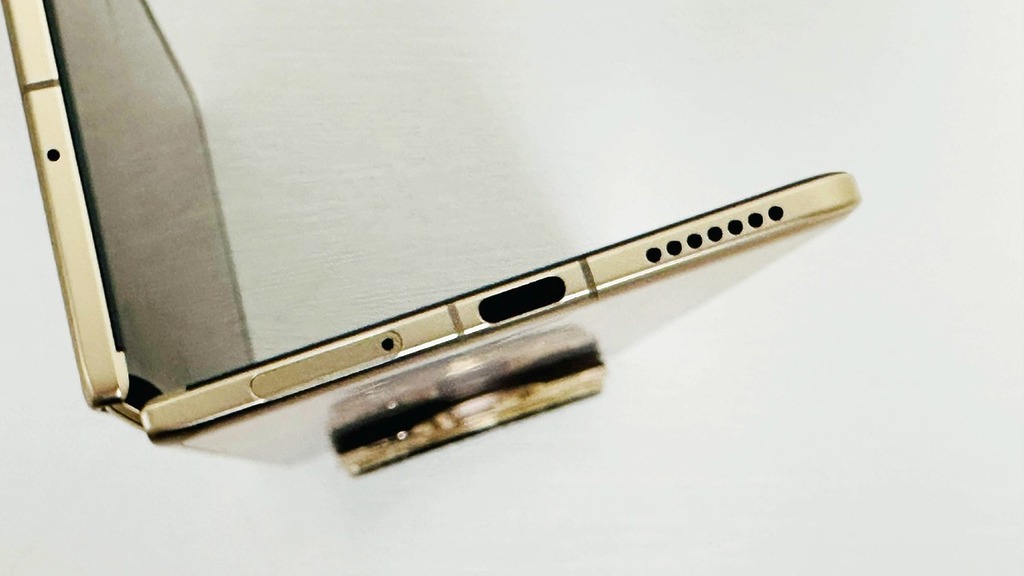手上的曙光金版，展開後厚度僅 4.2mm，比起 USB-C 插口僅厚丁點。