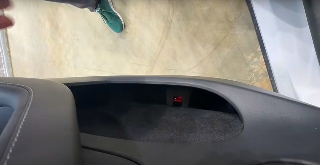 Tesla Model Y 後排座位的緊急開門掣,正正隱藏車門的貯物箱內⋯⋯