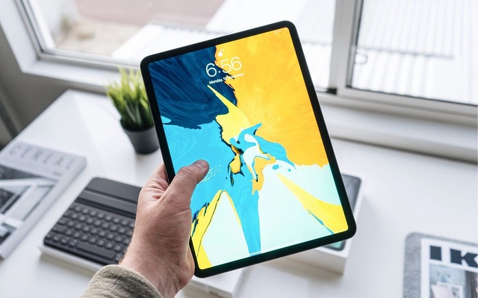 Person-holding-an-iPad-over-a-desk