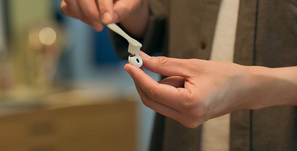 將牙刷浸入卸妝水讓刷毛完全浸透,拿著 AirPods 將要清潔的網罩朝上,打圈輕輕刷拭網罩約 15 秒。